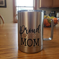 Snark and Spark stainless steel travel mug with Proud Rescue Mom text and paw print graphic on a wooden table.